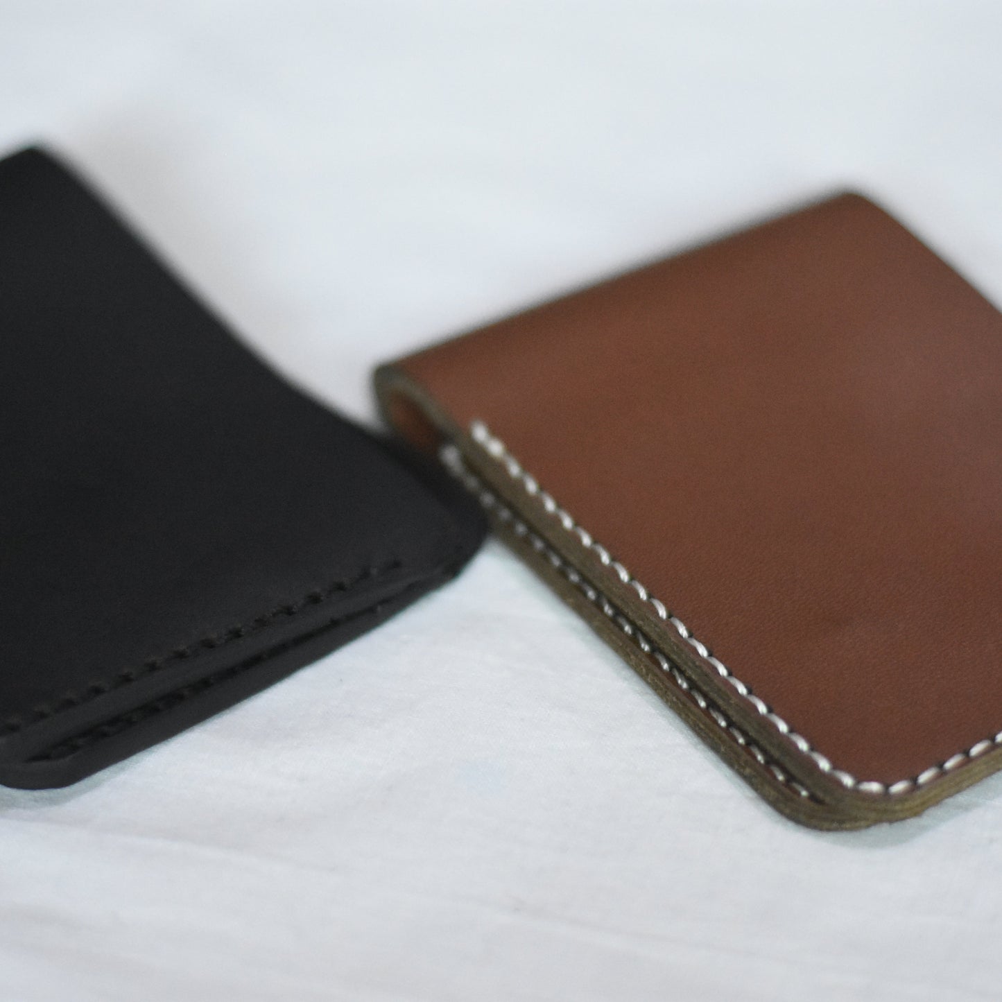 Black and brown leather wallets on a white background